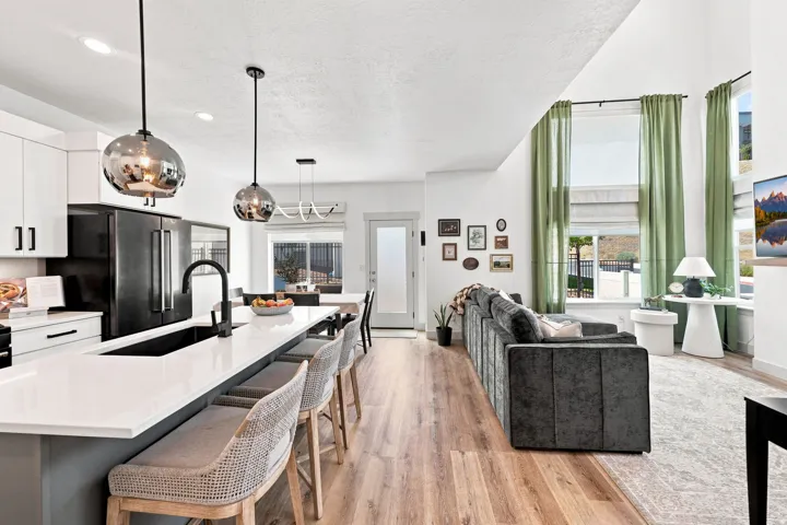 Kitchen island with white countertops, matte black sink and faucet, and pendant lighting