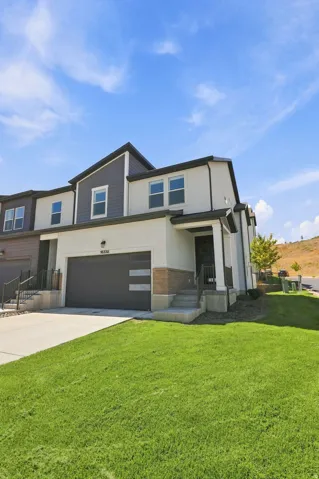 Modern townhome exterior with mixed material facade, an integrated garage, and a covered entry