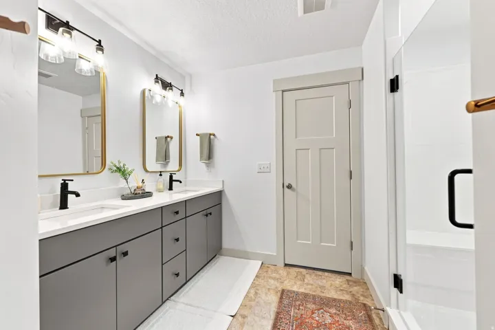 Dual vanity with matte black fixtures, rectangular undermount sinks, and white countertops