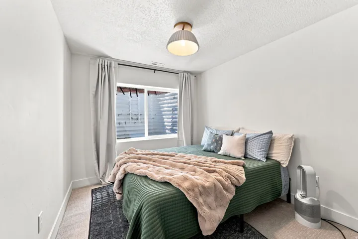 Carpeted flooring, window with white trim, and a semi-flush mount ceiling light fixture