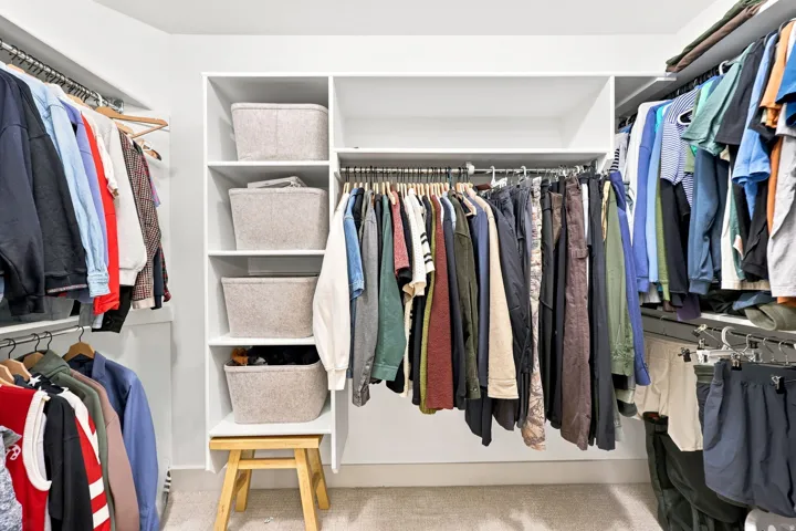 Built-in closet system featuring multiple hanging rods and integrated shelving