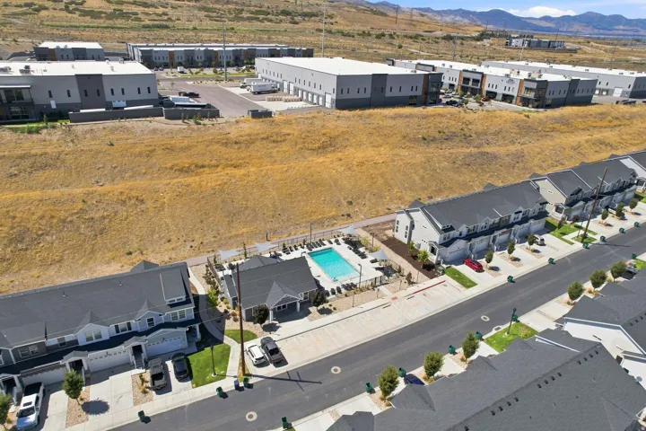 Community pool and clubhouse with surrounding residential townhomes featuring attached garages