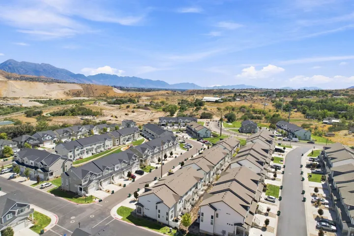 Newly constructed residential development featuring multi-story townhomes, paved roadways, and landscaped grounds