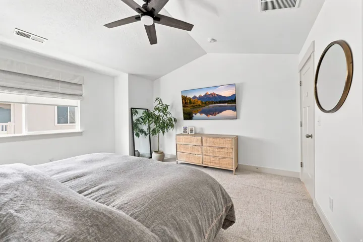 Vaulted ceiling with a ceiling fan, recessed lighting, and a window with a fabric shade