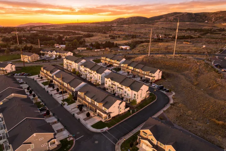 Modern townhome community featuring multi-level residences, attached garages, and paved roadways