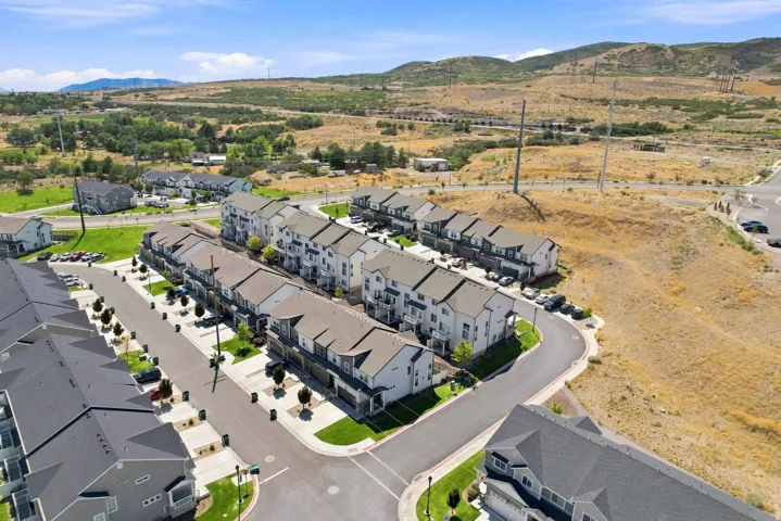Modern townhome community featuring multi-level residences, attached garages, and paved roadways