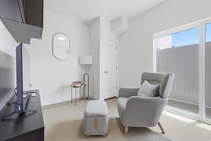 White interior walls with wall-mounted cabinetry, a sliding glass door, and hard surface flooring