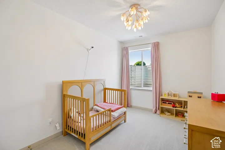 White walls, light-colored carpeting, and a window with natural light