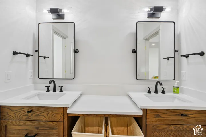 Dual vanity with undermount sinks, wood-finish cabinetry, white countertops, and matte black fixtures