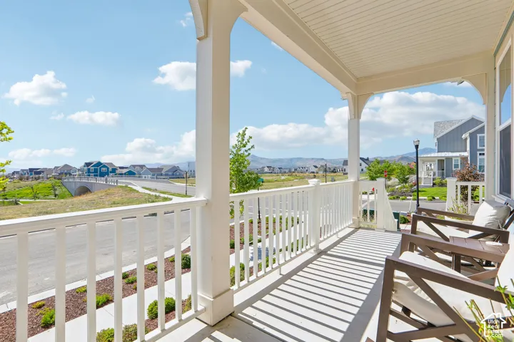 Covered front porch with white columns, balustrade, and a beadboard ceiling