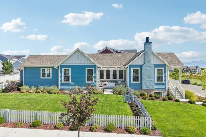 Vibrant blue siding exterior with white trim, a gabled roofline, and a prominent chimney feature