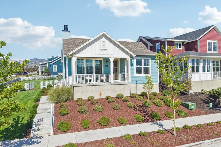 Light blue siding, white trim, covered front porch, concrete steps, and a picket fence