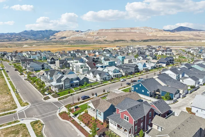 Modern residential development with a variety of architectural styles, paved streets, sidewalks, and landscaped common areas