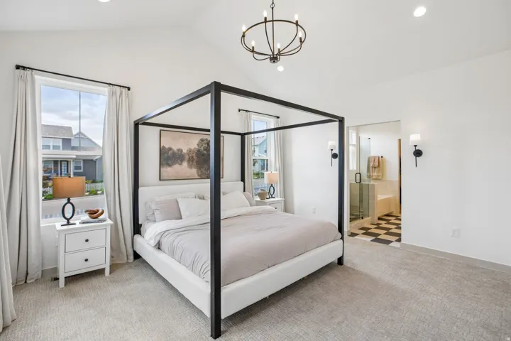 Vaulted ceiling with an overhead chandelier, recessed lighting, and soft carpet flooring