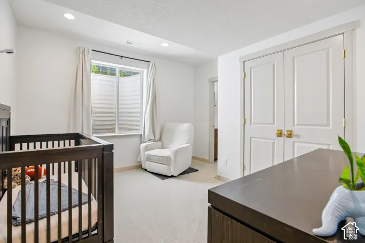 Recessed lighting, light-toned carpeting, window with privacy blinds, and white paneled double doors with brass-tone hardware
