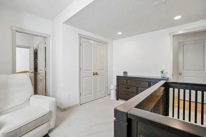 White walls with recessed lighting, light-toned carpet flooring, and white trim