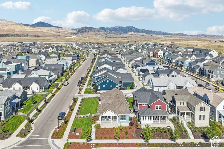 Expansive residential community with varied architectural styles, manicured landscaping, and mountain backdrops