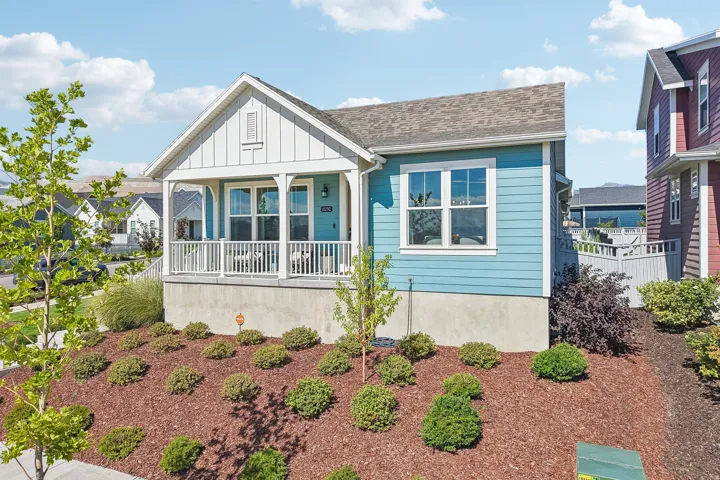 Light blue siding with white trim, covered front porch, and a gable roof