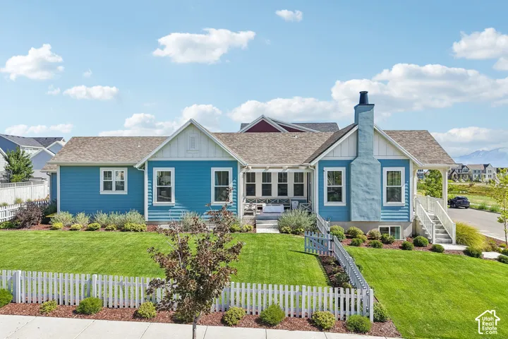 Vibrant blue siding exterior with white trim, a gabled roofline, and a prominent chimney feature