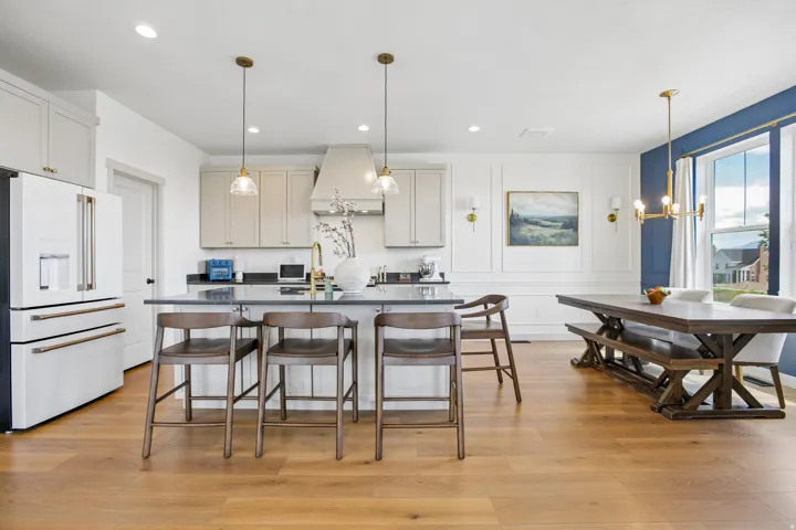 Hardwood-finish flooring, white paneled wall accents, and an expansive window with a broad sill