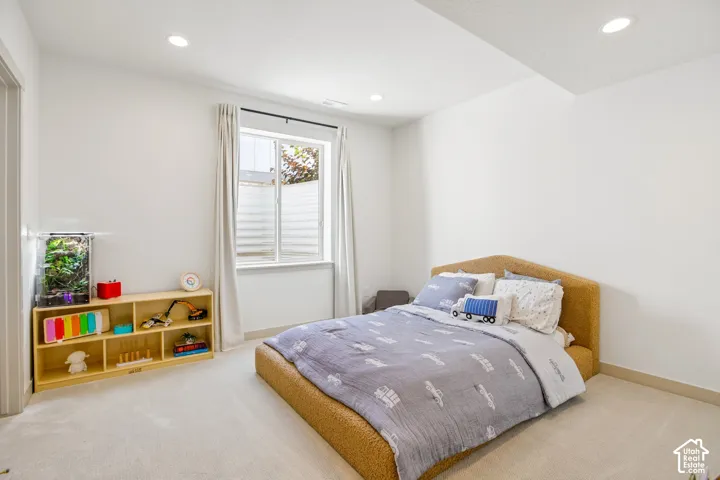 Wall-to-wall carpeting, recessed lighting, and a single window with blinds and drapes