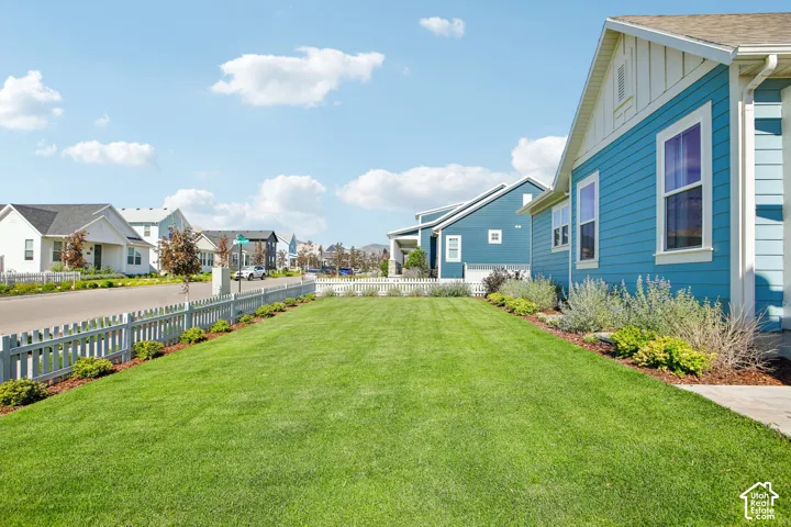 Expansive front lawn with a white picket fence