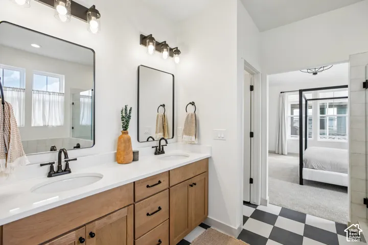 Double vanity with dual undermount sinks, quartz countertops, and wood-finish cabinetry