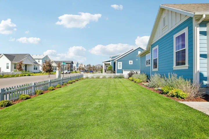 Expansive front lawn with a white picket fence