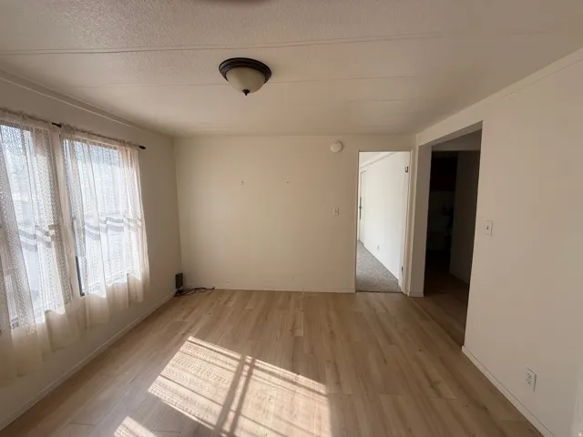 Light wood-finish flooring with white walls and a ceiling-mounted light fixture