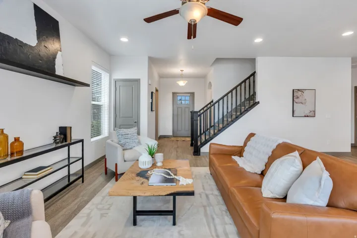Open-concept living space with wood-finish flooring, recessed lighting, and a ceiling fan