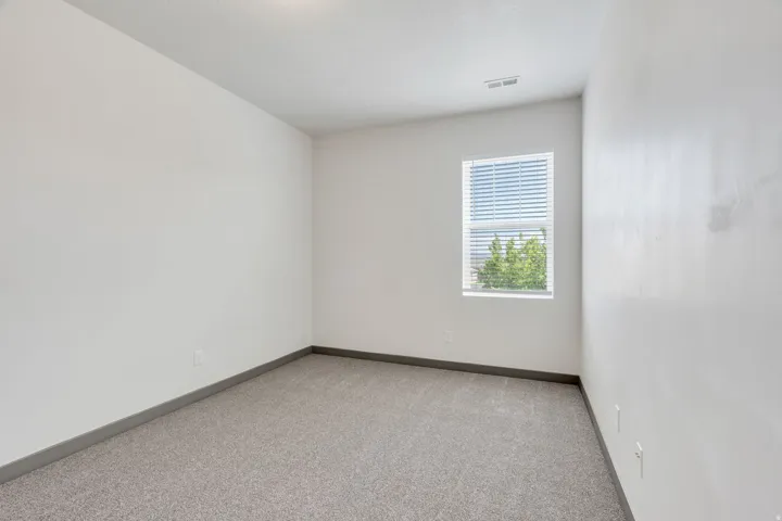 Neutral-toned carpeting with a modern baseboard trim