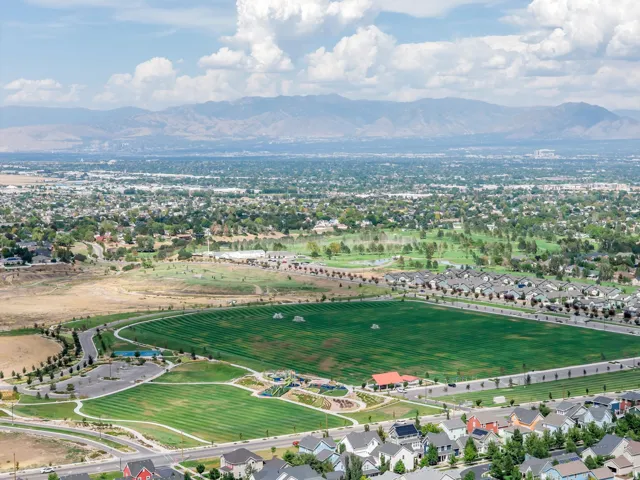 Expansive community with manicured green spaces, recreational fields, and mountain scenery