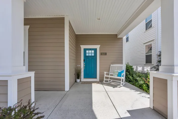 Covered front porch featuring wide concrete flooring and decorative columns