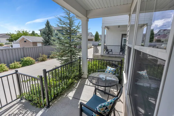 Covered porch with concrete flooring and black metal railings