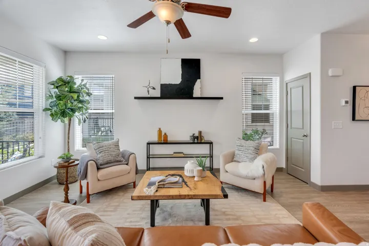 Living area featuring wood-finish flooring, recessed lighting, a ceiling fan, and multiple windows with blinds