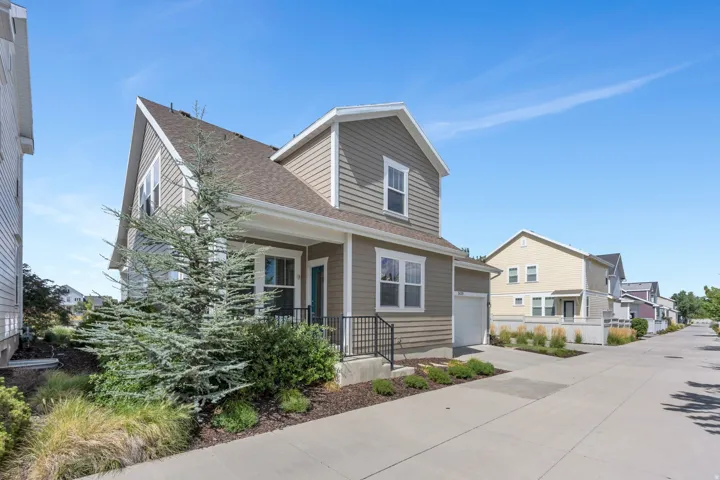 Siding exterior with white trim, covered front porch, and an attached single-car garage