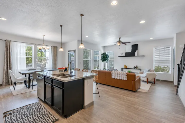 Open-concept living area with wood-finish flooring, recessed lighting, and multiple windows