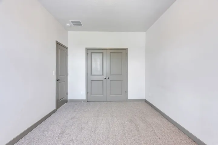 Plush carpet flooring, white walls, and two-panel interior doors