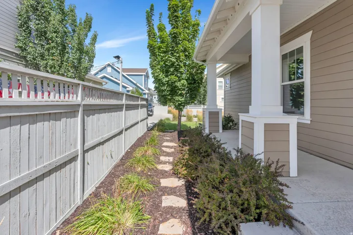 Covered front porch with white columns, horizontal siding exterior, and a white framed window