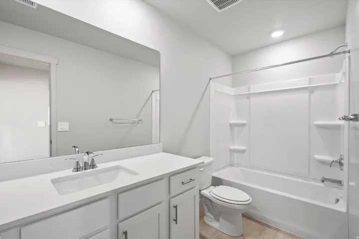 **Disclaimer** Interior package has upgrades not photographed.  Modern bathroom featuring a white vanity with ample storage, quartz countertop, and chrome faucet fixtures