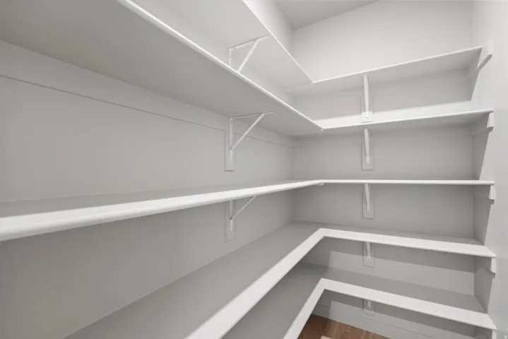 **Disclaimer** Interior package has upgrades not photographed.  Pantry featuring expansive white shelving and light wood-finish flooring