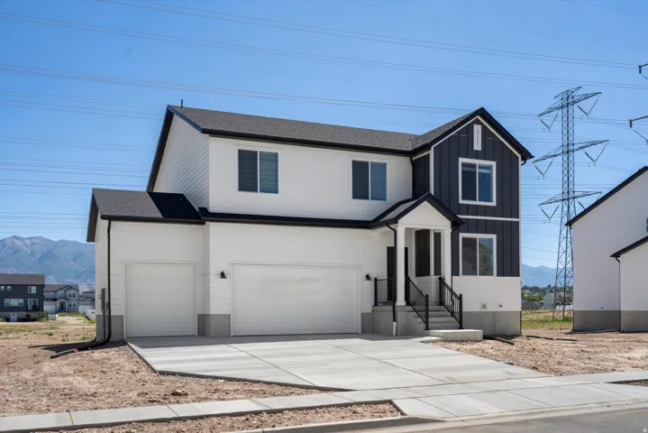 **Disclaimer** Exterior elevation may vary. White siding exterior with dark vertical accent siding, attached two-car garage, covered porch entry, and concrete driveway