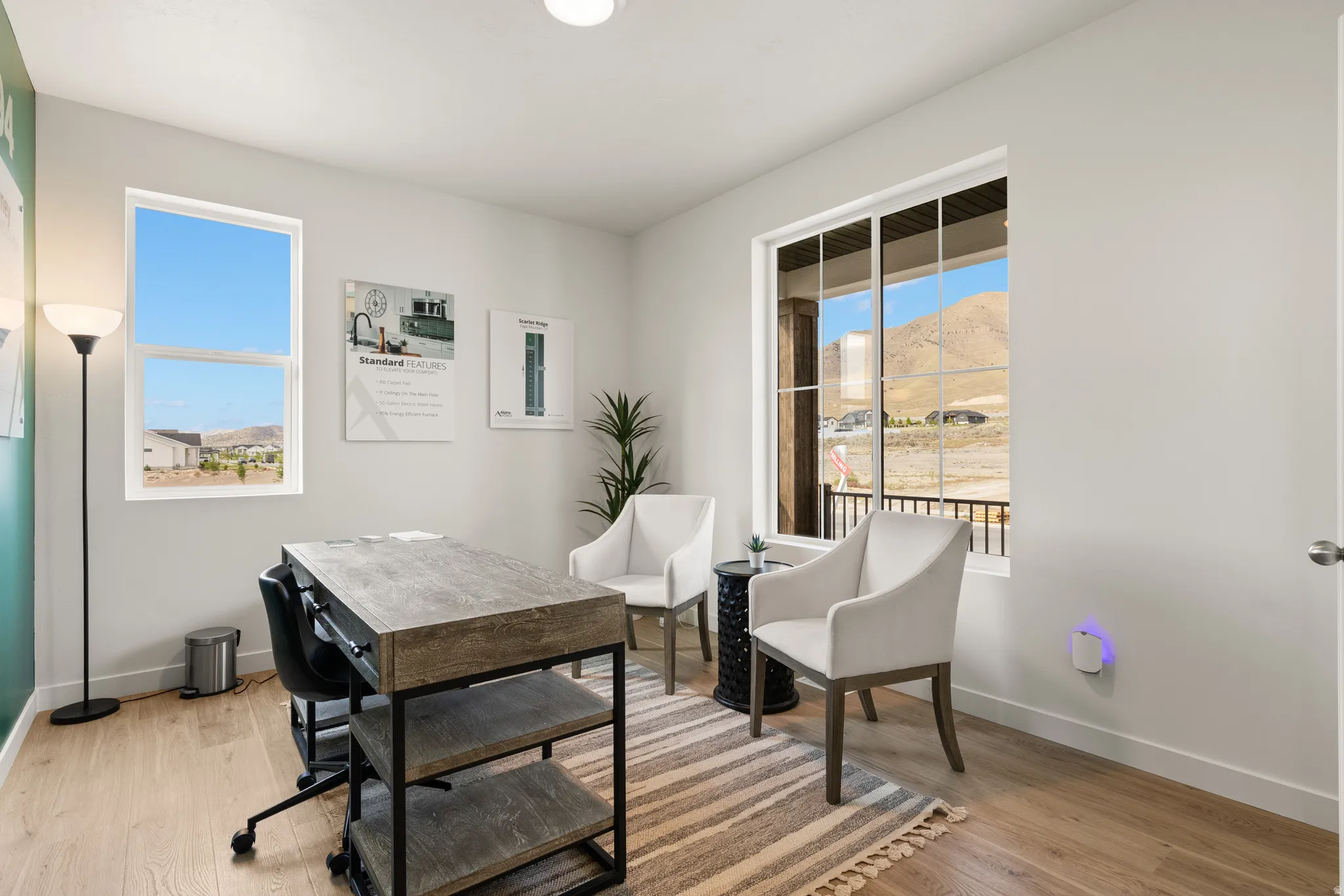 Light-filled interior space featuring large windows, wood-finish flooring, and white walls
