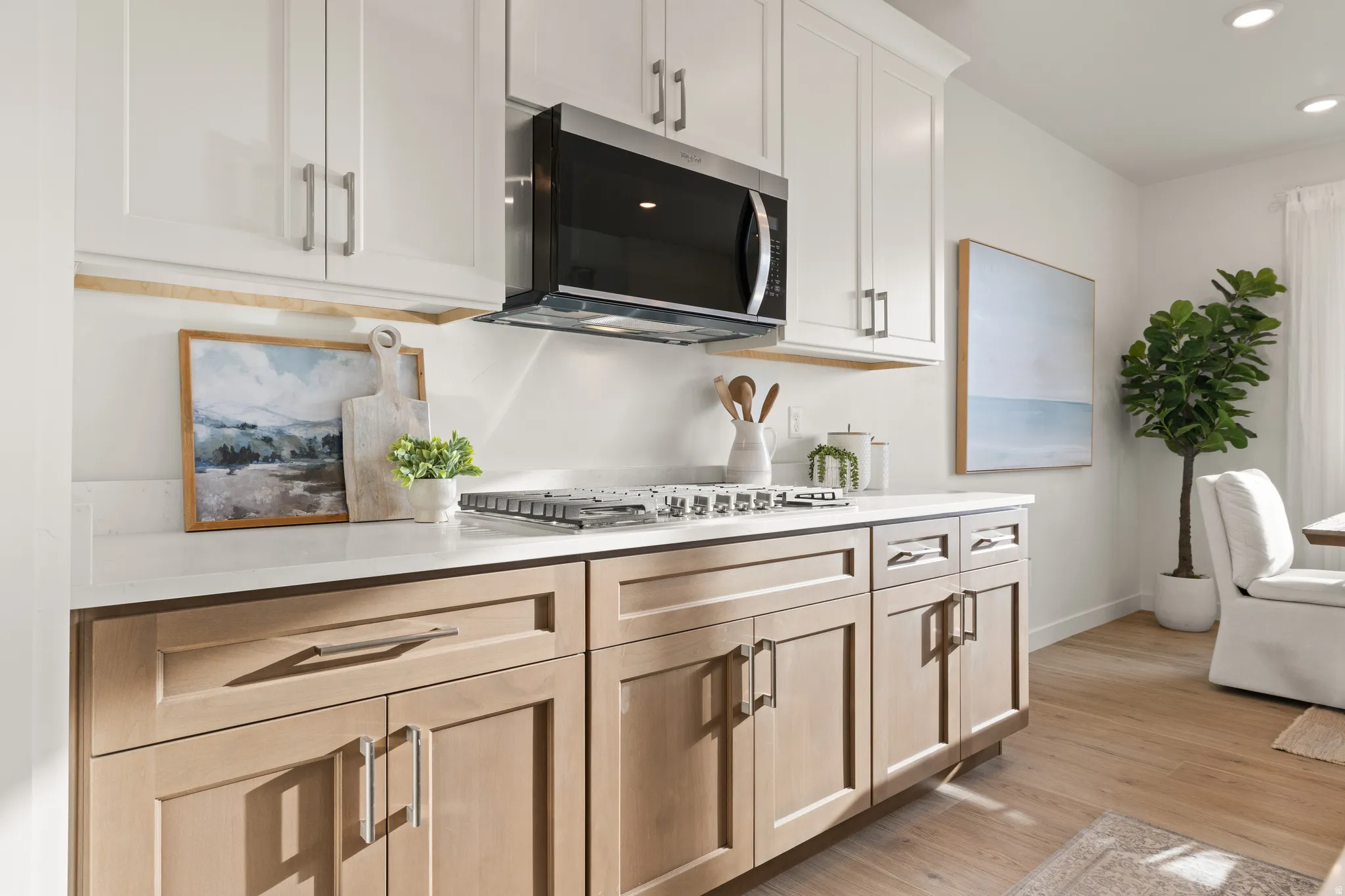 Two-tone cabinetry with upper white shaker-style cabinets and lower wood-finish cabinets