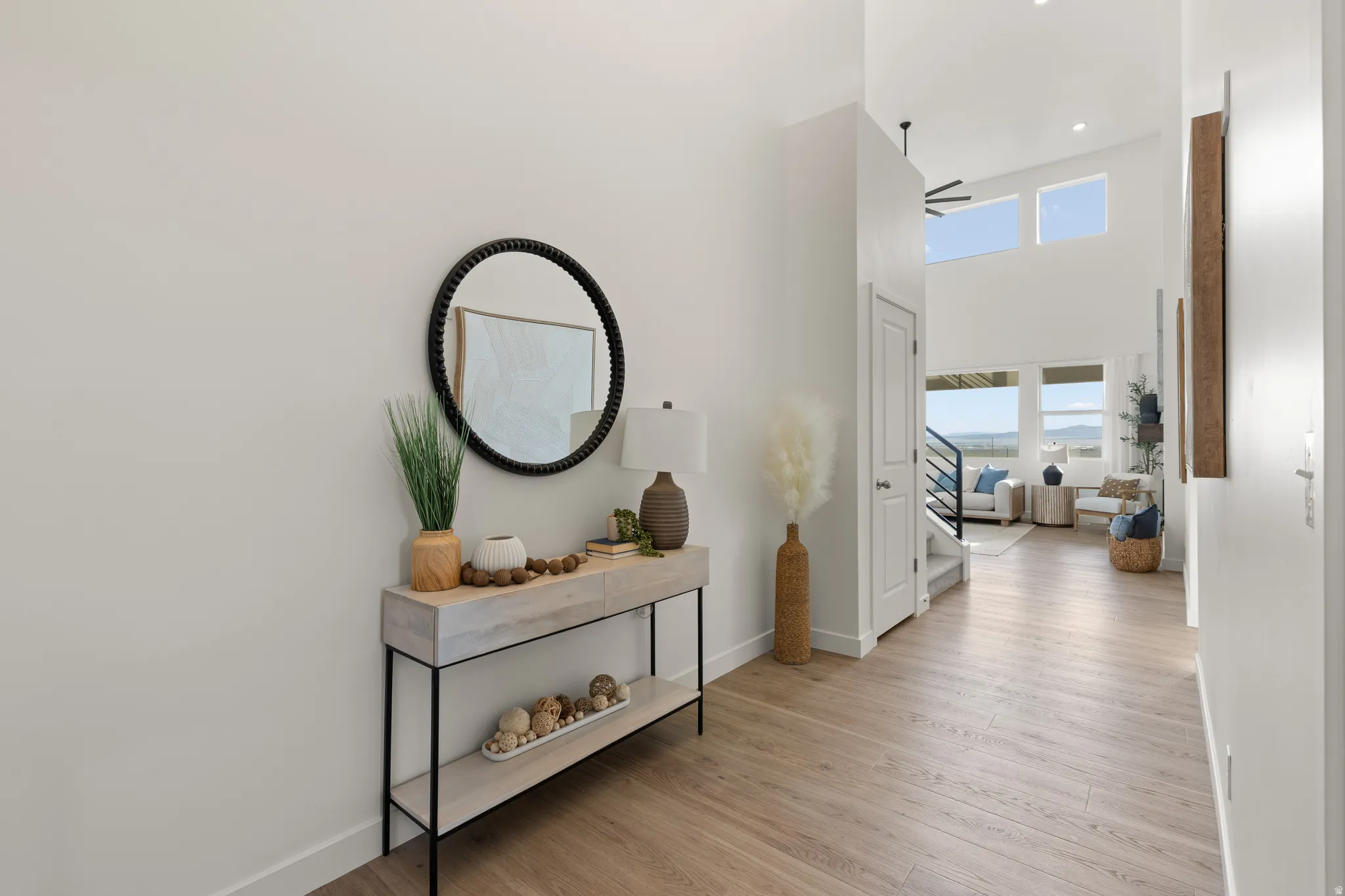 Vaulted ceilings with clerestory windows, wood-finish flooring, and bright white walls