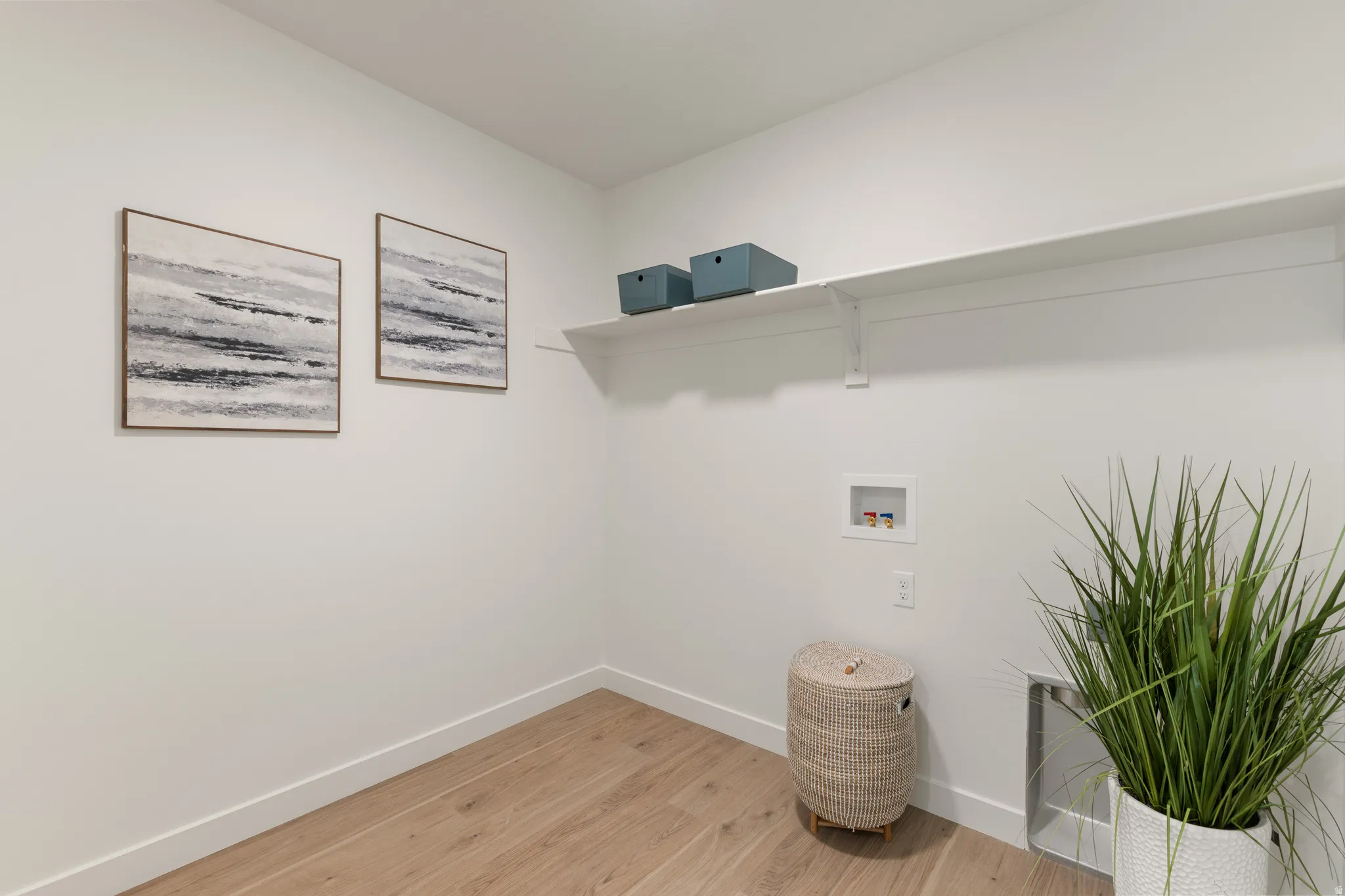 Bright interior space with wood-finish flooring and a white built-in shelf