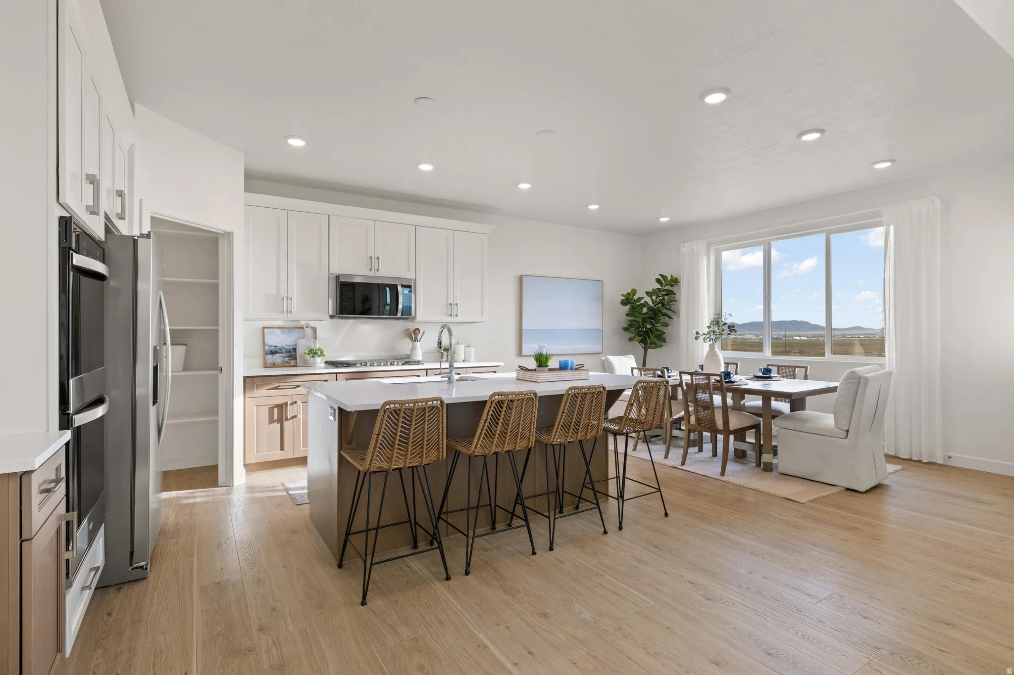 Spacious kitchen with a central island, recessed lighting, stainless steel appliances, and wood-finish flooring