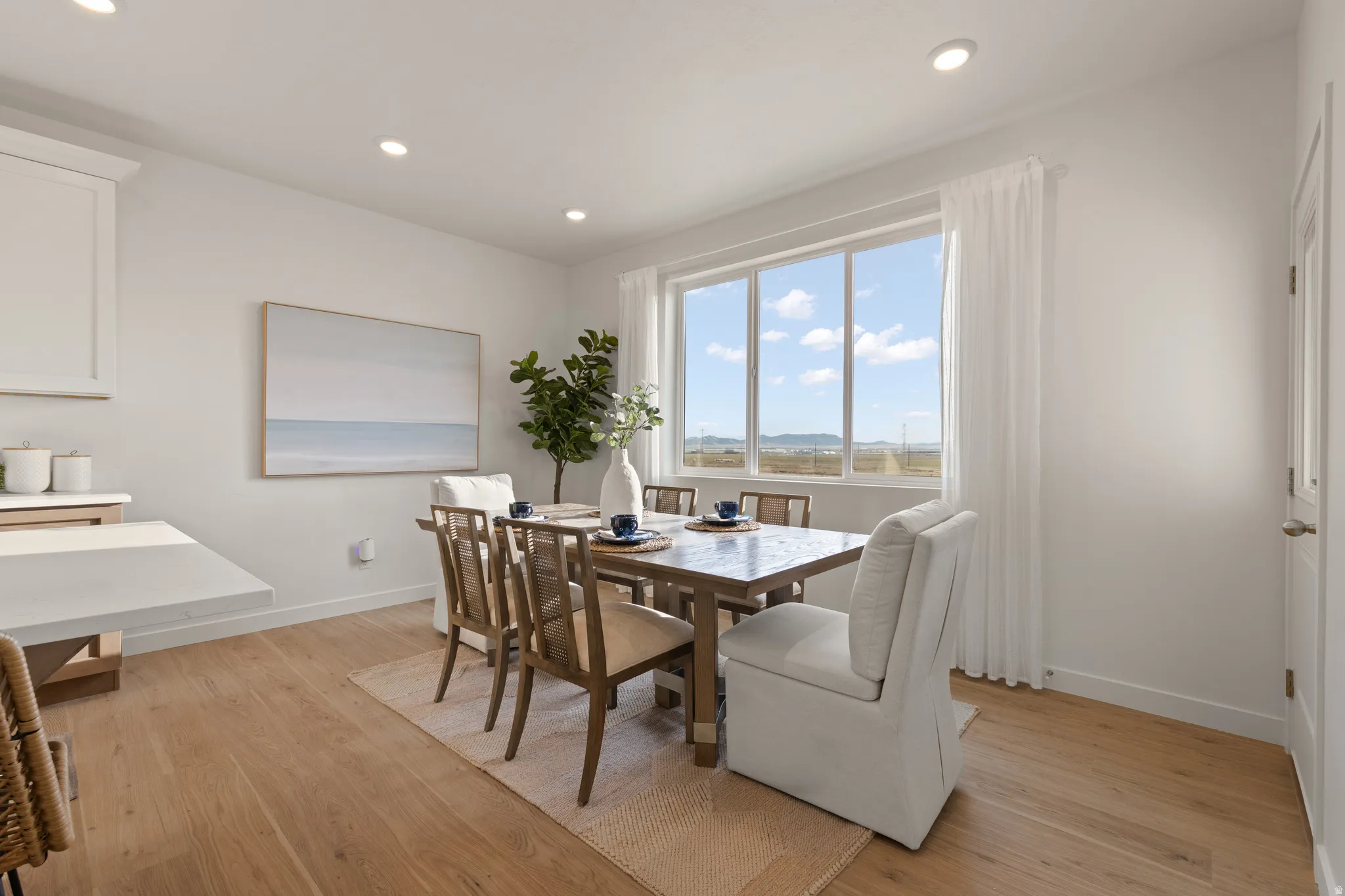 Expansive window with distant scenery, wood-finish flooring, recessed lighting, and a built-in countertop extension