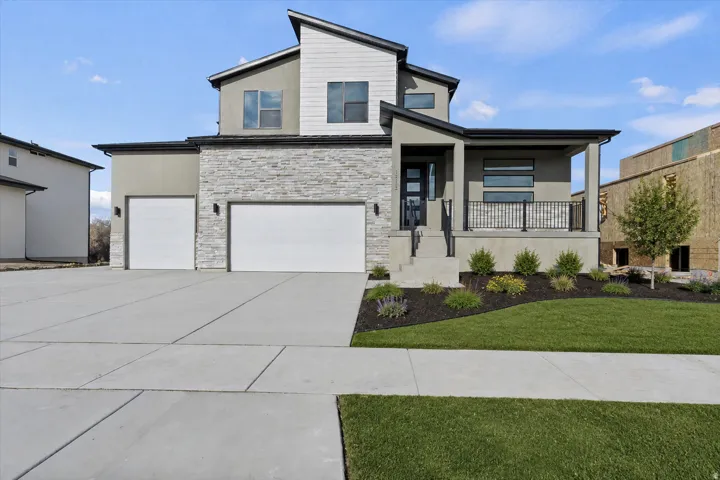 Contemporary exterior with multiple rooflines, stone and stucco facade, and two garage doors
