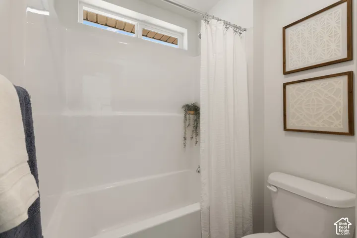 White tub and shower combination with an integrated shelf and frosted transom window